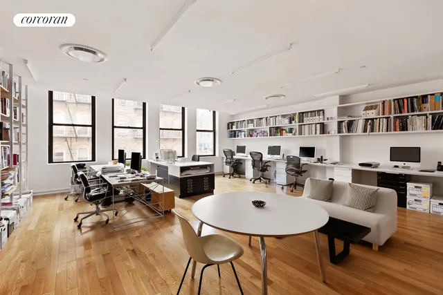 a living room with furniture floor to ceiling window and a book shelf