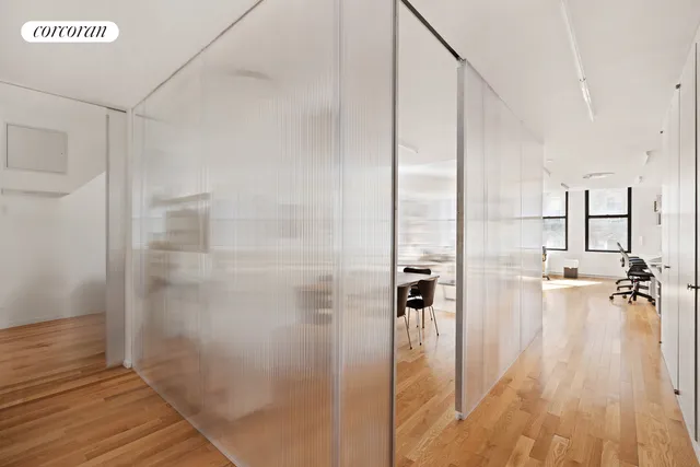 a living room with furniture large window and wooden floor