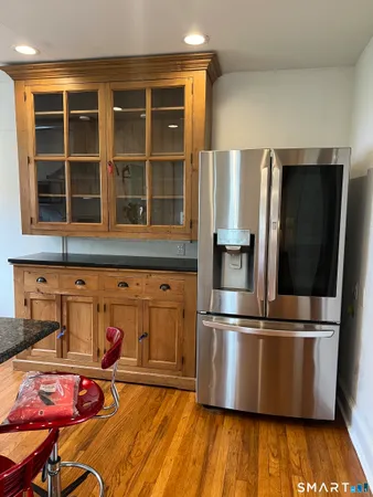 a kitchen with granite countertop a refrigerator and a stove top oven