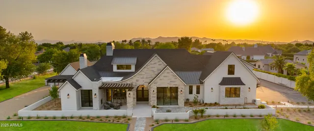 an aerial view of a house with swimming pool and a yard