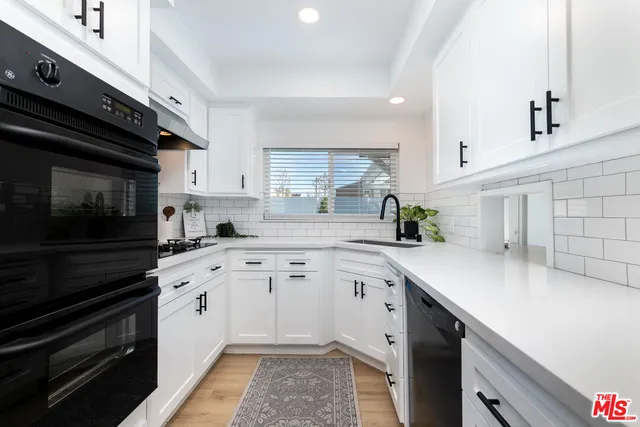 a kitchen with a sink stove and cabinets
