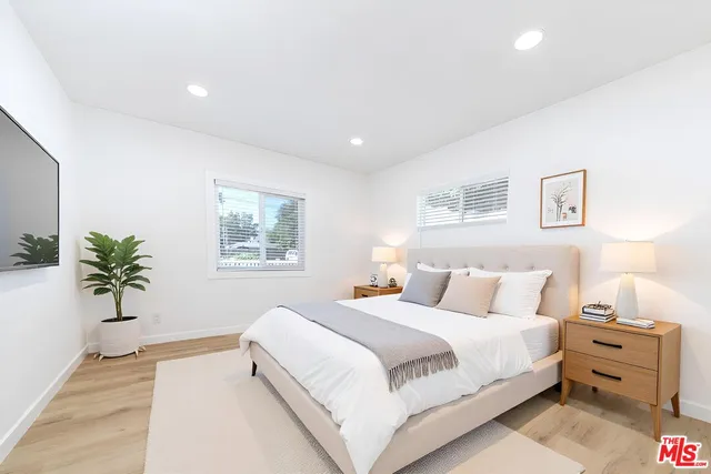 a bedroom with a large bed and a potted plant