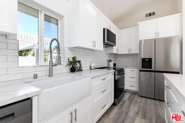 a kitchen with white cabinets and stainless steel appliances