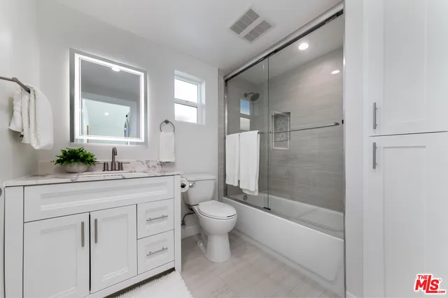 a bathroom with a double vanity sink toilet and shower