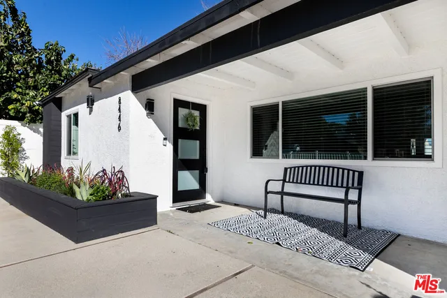 a view of a house with a flower garden and chair