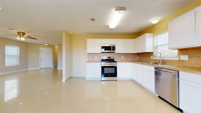 a large kitchen with cabinets and stainless steel appliances