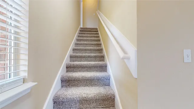a view of staircase with white walls and windows