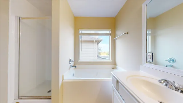a bathroom with a tub sink and mirror