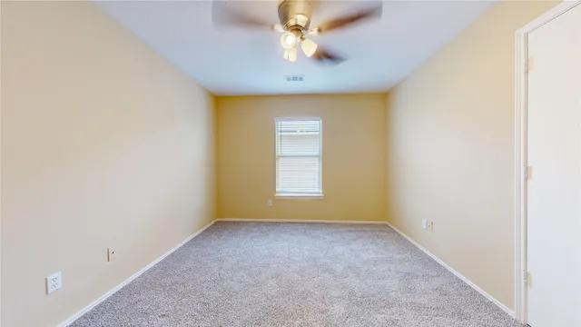 a view of room with window and ceiling fan