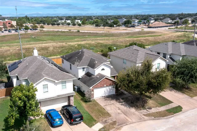 an aerial view of residential houses with outdoor space and lake view