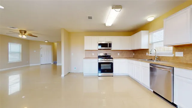 a kitchen with stainless steel appliances a stove a sink and a refrigerator