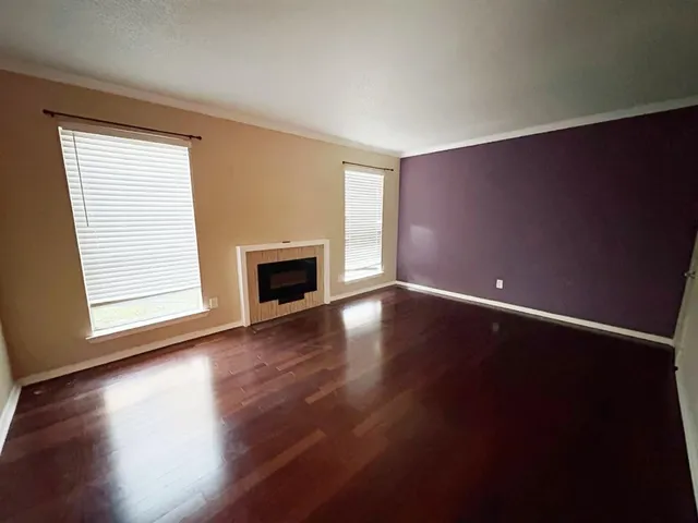 a view of empty room with wooden floor and fireplace
