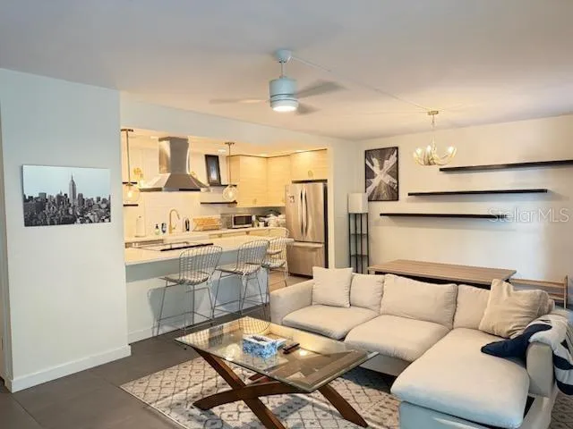 a living room with stainless steel appliances kitchen island granite countertop furniture and a view of kitchen