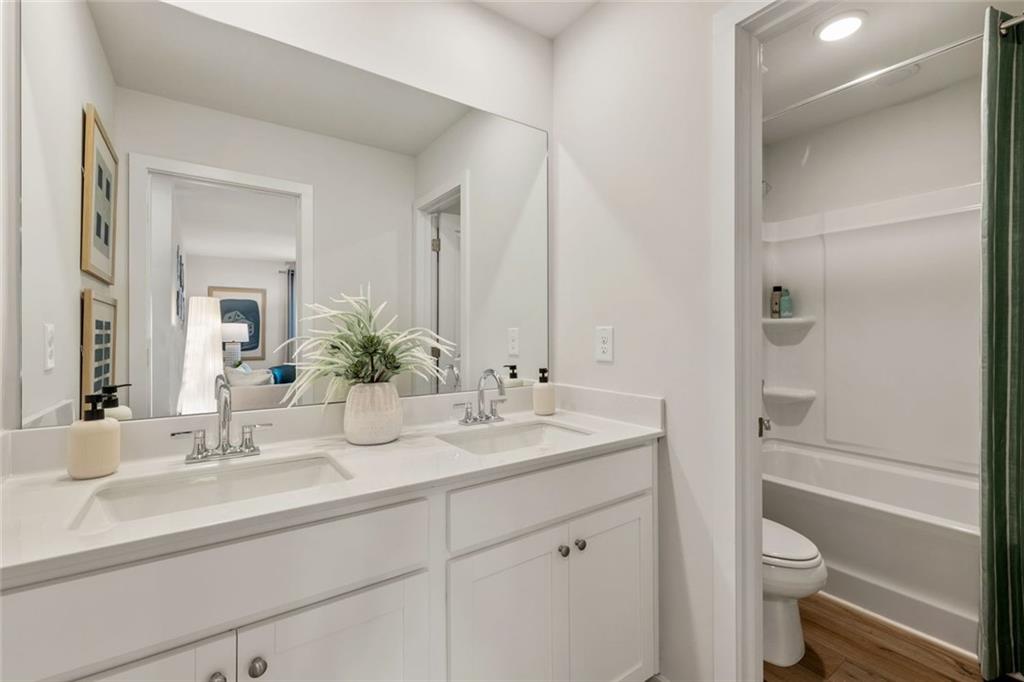 2682 Harbor Rdg Pass Gainesville, GA 30507 - Photo 30 of 42 a bathroom with a sink a toilet and a large mirror