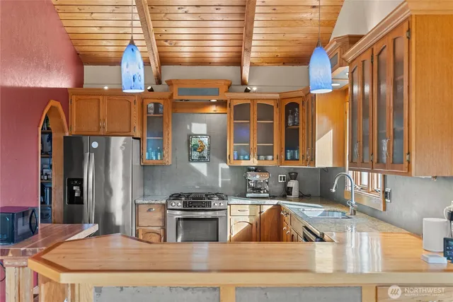 a kitchen with stainless steel appliances granite countertop a sink a stove and a refrigerator