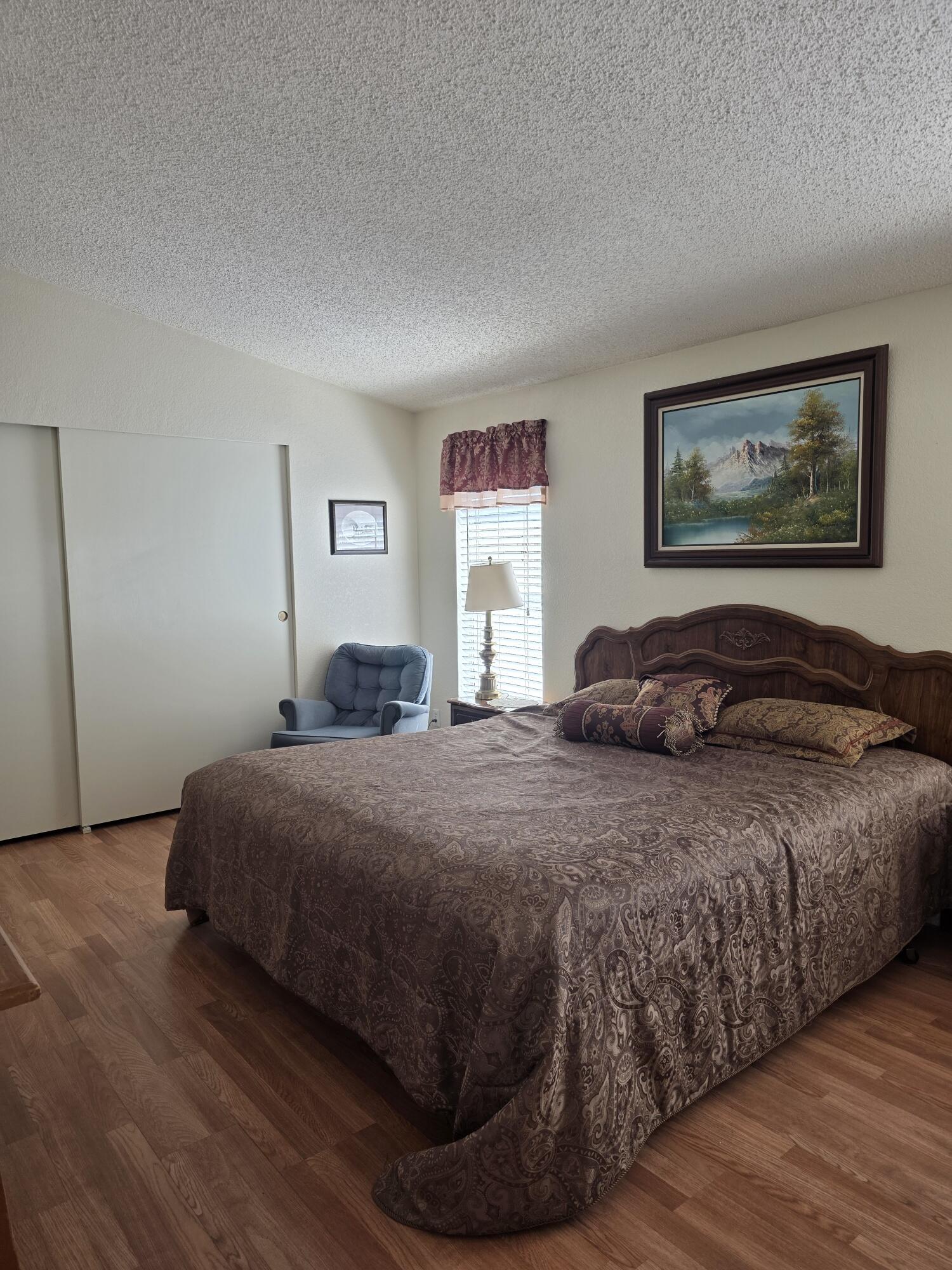 10595 Hot Mineral Spa Road, Unit 195 Niland, CA 92257 - Photo 13 of 32 a bedroom with a bed and wooden floor