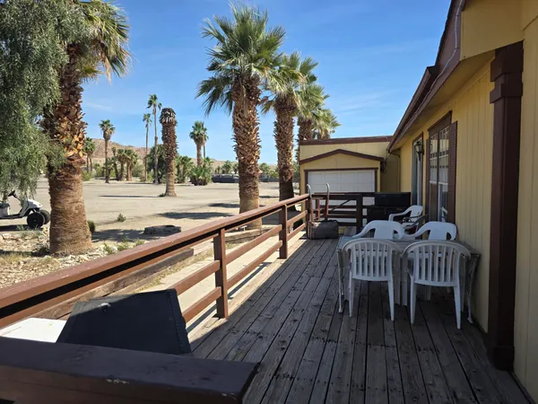a view of a roof deck with table and chairs with wooden floor and fence