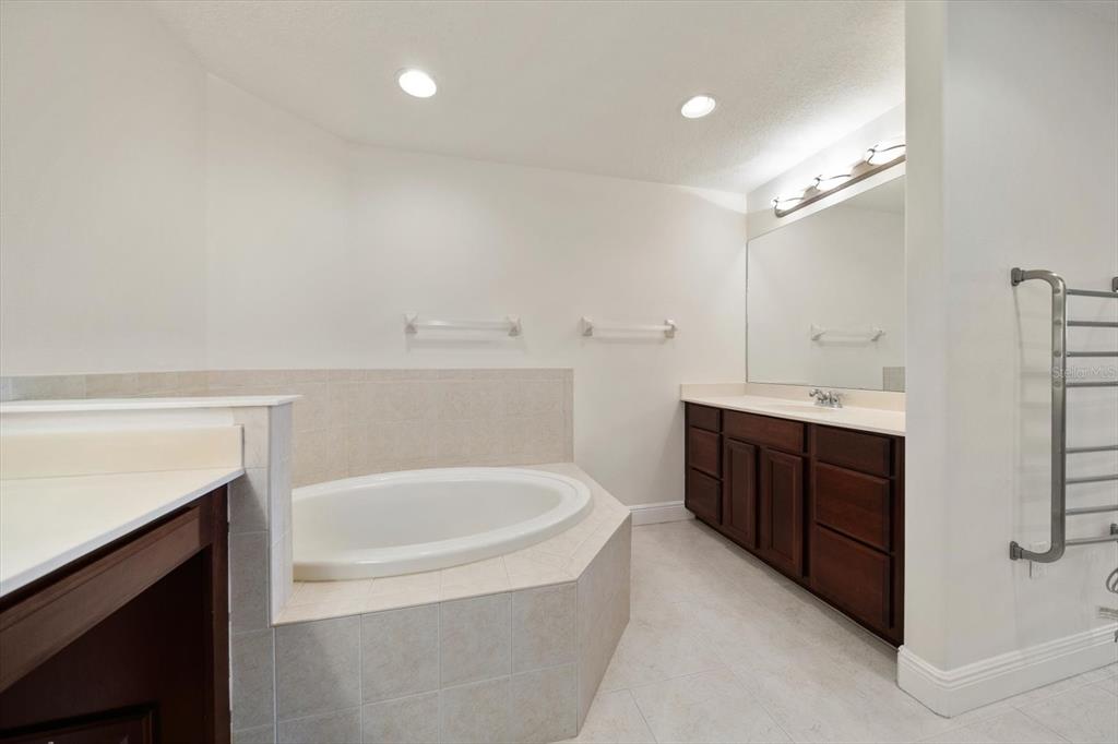 7069 Key Haven Road, Unit 304 Seminole, FL 33777 - Photo 12 of 50 a spacious bathroom with a double vanity sink a mirror and a bathtub