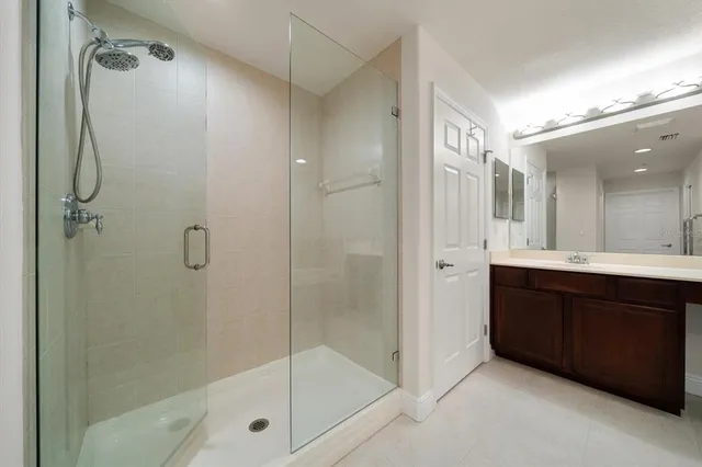 a bathroom with a glass shower door and a sink