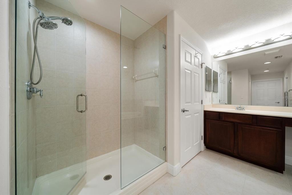 7069 Key Haven Road, Unit 304 Seminole, FL 33777 - Photo 13 of 50 a bathroom with a glass shower door and a sink