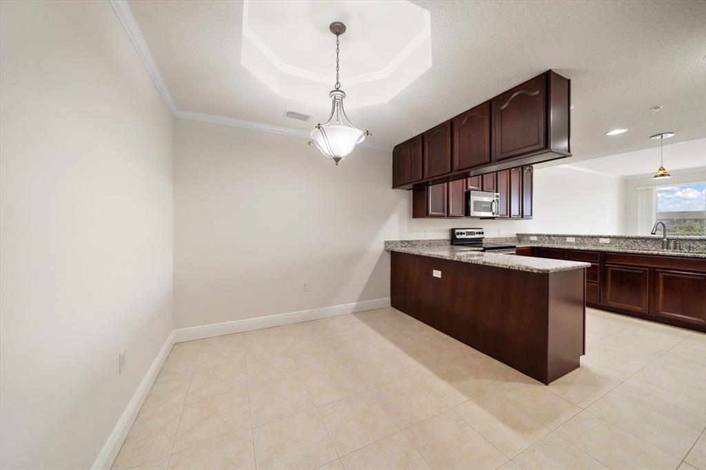 7069 Key Haven Road, Unit 304 Seminole, FL 33777 - Photo 39 of 50 a kitchen with stainless steel appliances granite countertop a sink a stove and a refrigerator