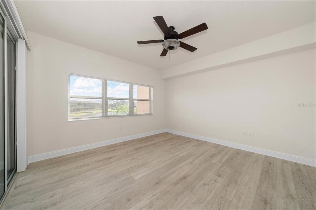 7069 Key Haven Road, Unit 304 Seminole, FL 33777 - Photo 42 of 50 an empty room with wooden floor fan and windows