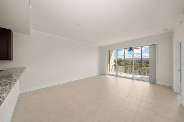 an empty room with a chandelier fan and windows