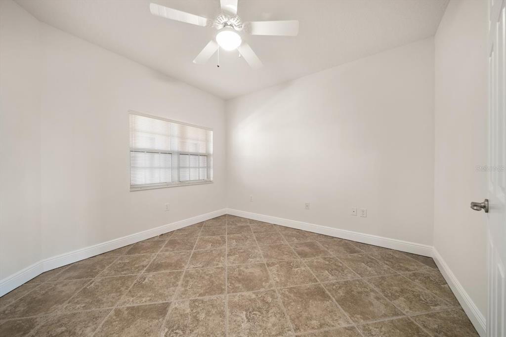 7069 Key Haven Road, Unit 304 Seminole, FL 33777 - Photo 44 of 50 an empty room with a chandelier fan and windows