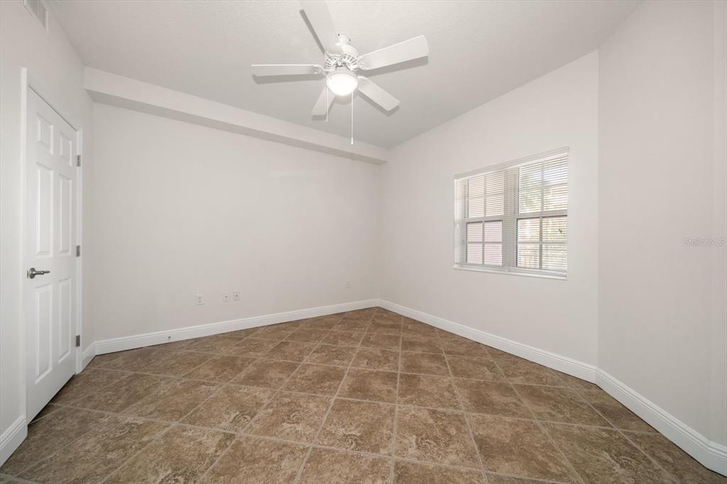 7069 Key Haven Road, Unit 304 Seminole, FL 33777 - Photo 46 of 50 an empty room with windows and ceiling fan