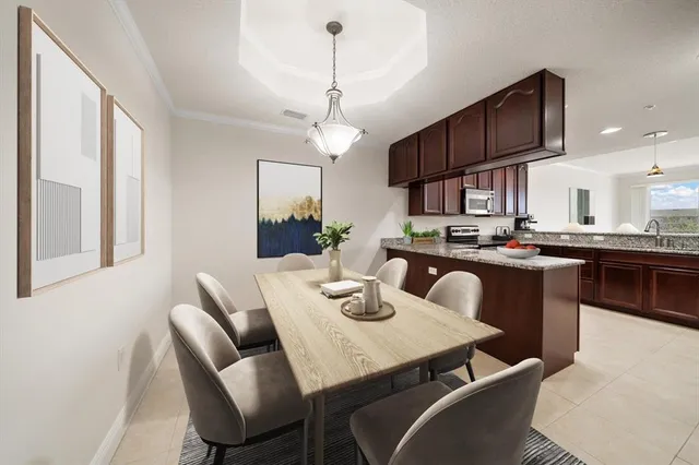 a view of a dining room with furniture a kitchen and chandelier