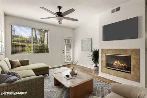 a living room with furniture a flat screen tv and a fireplace