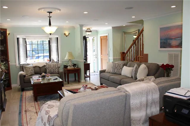 a living room with furniture a large window and a chandelier