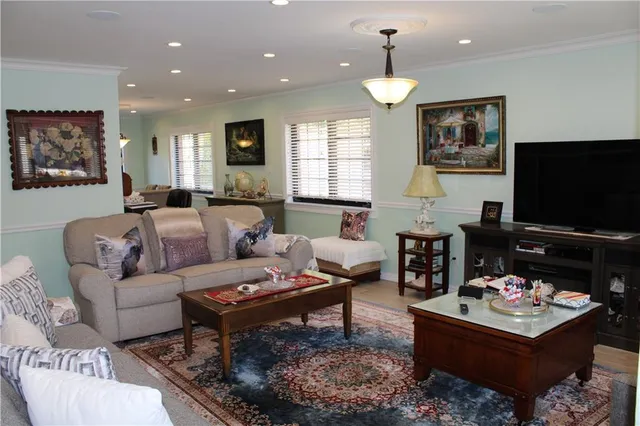 a living room with furniture a dining table and a flat screen tv