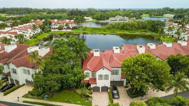 an aerial view of residential houses with outdoor space and lake view
