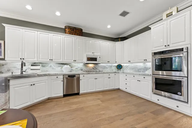 a kitchen with granite countertop white cabinets stainless steel appliances and a sink