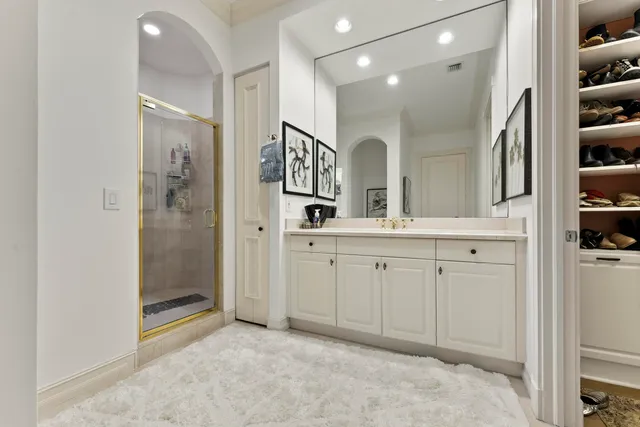 a spacious bathroom with a shower a sink and a mirror