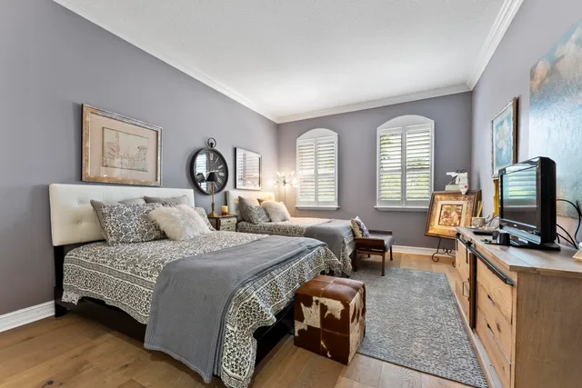 a spacious bedroom with a bed a couch and a flat tv screen on a dresser