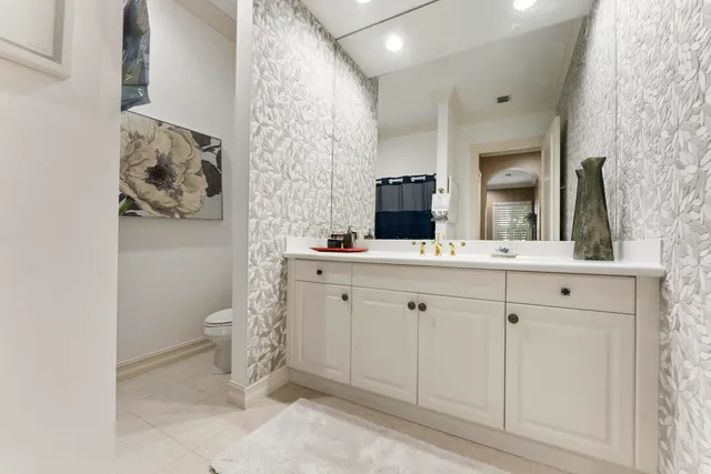 a bathroom with a sink vanity mirror and toilet