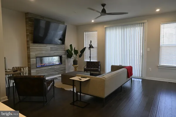 a living room with furniture a clock on wall and a window