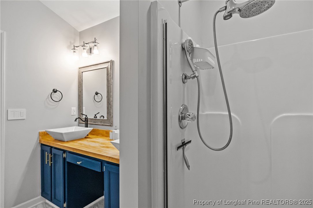 5302 Middleton Road Durham, NC 27713 - Photo 27 of 40 a bathroom with a granite countertop sink a mirror and a shower