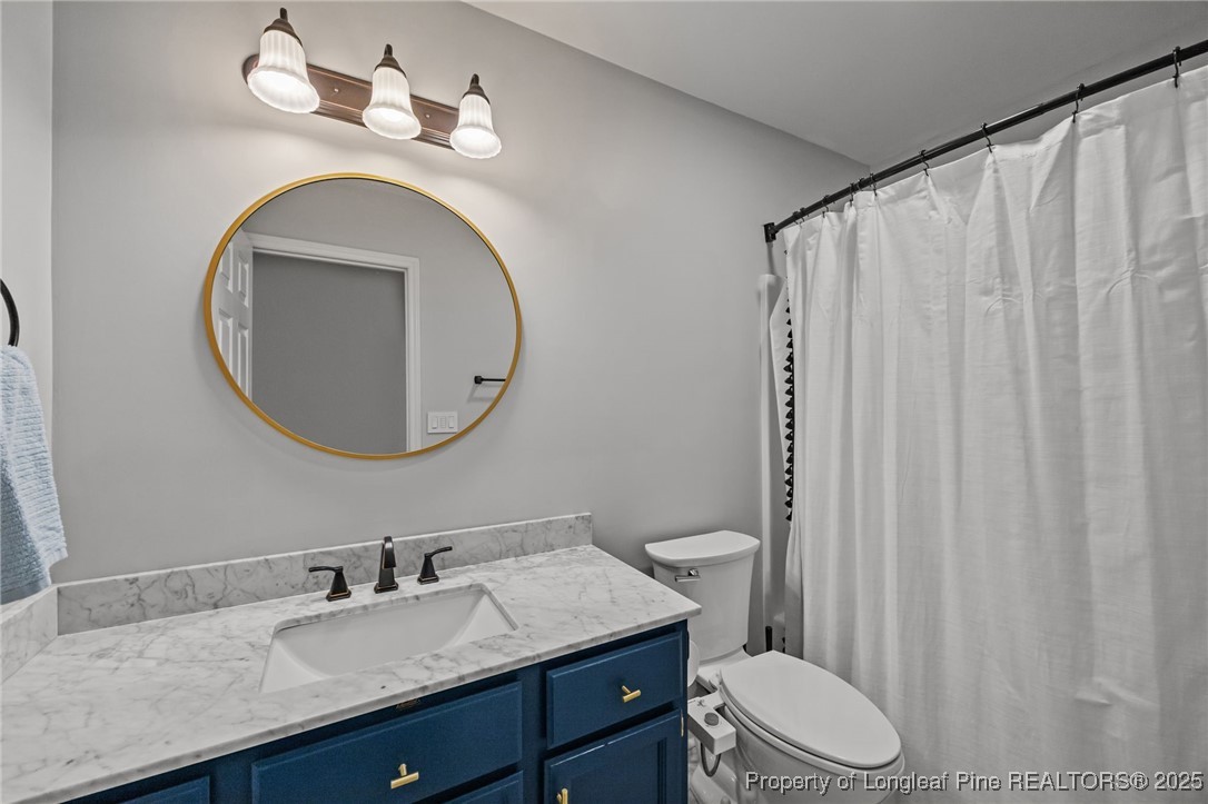 5302 Middleton Road Durham, NC 27713 - Photo 32 of 40 a bathroom with a granite countertop sink vanity mirror and toilet
