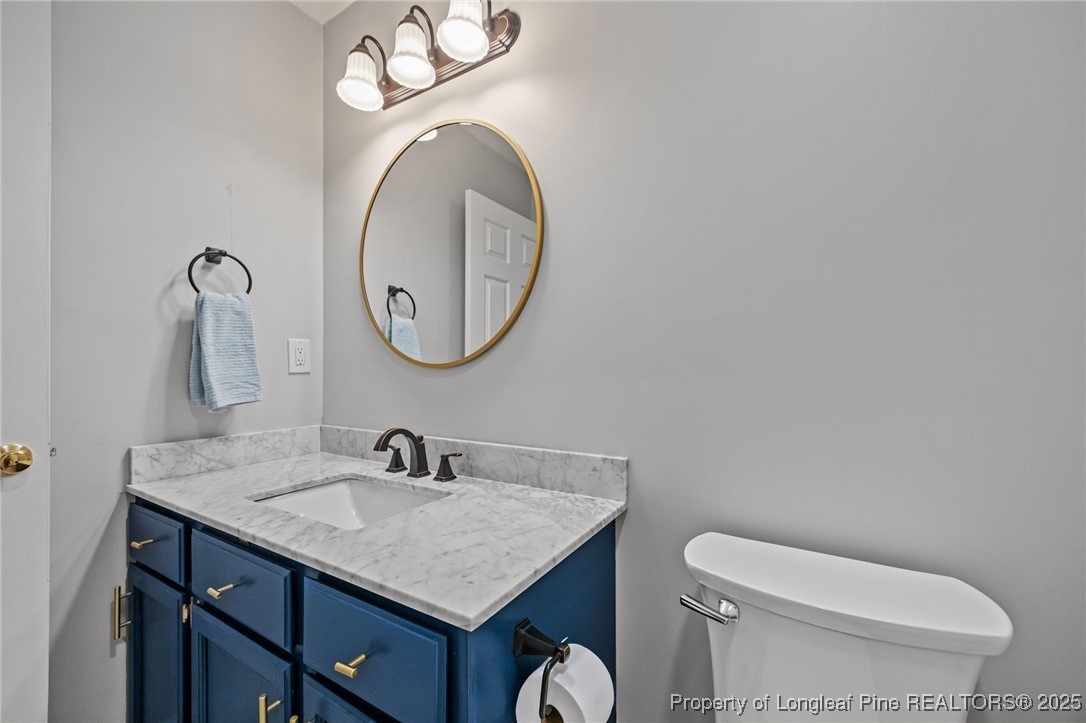 5302 Middleton Road Durham, NC 27713 - Photo 33 of 40 a bathroom with a toilet a sink and mirror