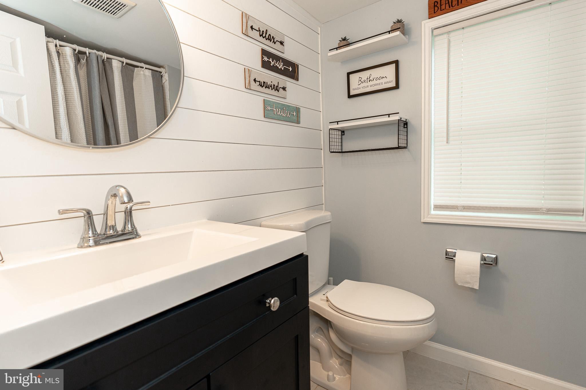 220 Pinewood Road Baltimore, MD 21222 - Photo 22 of 45 a bathroom with a sink a toilet and mirror