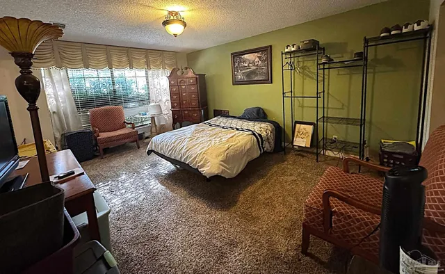 a bedroom with a bed window and a mirror