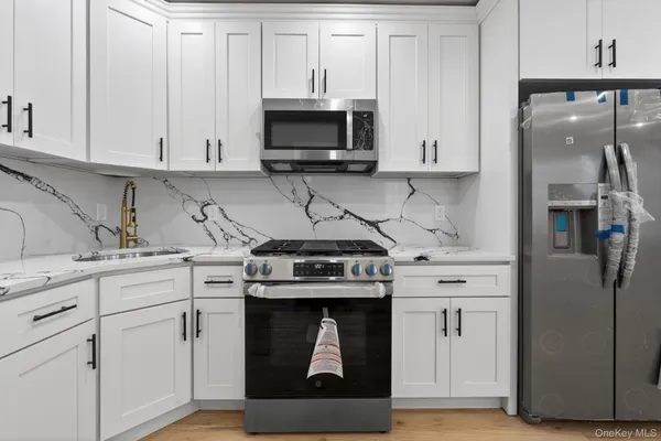 a kitchen with stainless steel appliances granite countertop a stove a refrigerator and a sink
