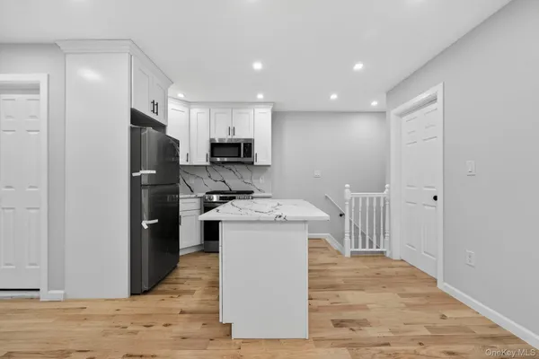 a kitchen with kitchen island a stove a refrigerator and a sink