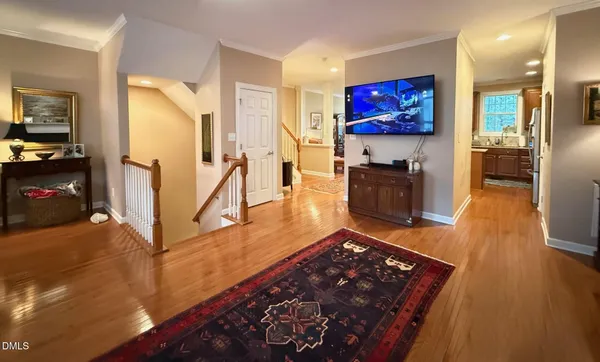 a living room with stainless steel appliances furniture and a flat screen tv