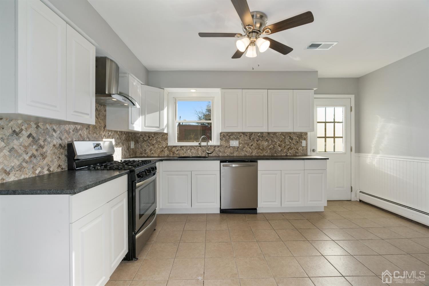 403 Fulton Street Middlesex, NJ 08846 - Photo 12 of 31 a kitchen with stainless steel appliances granite countertop a sink a stove a refrigerator a microwave oven with white cabinets