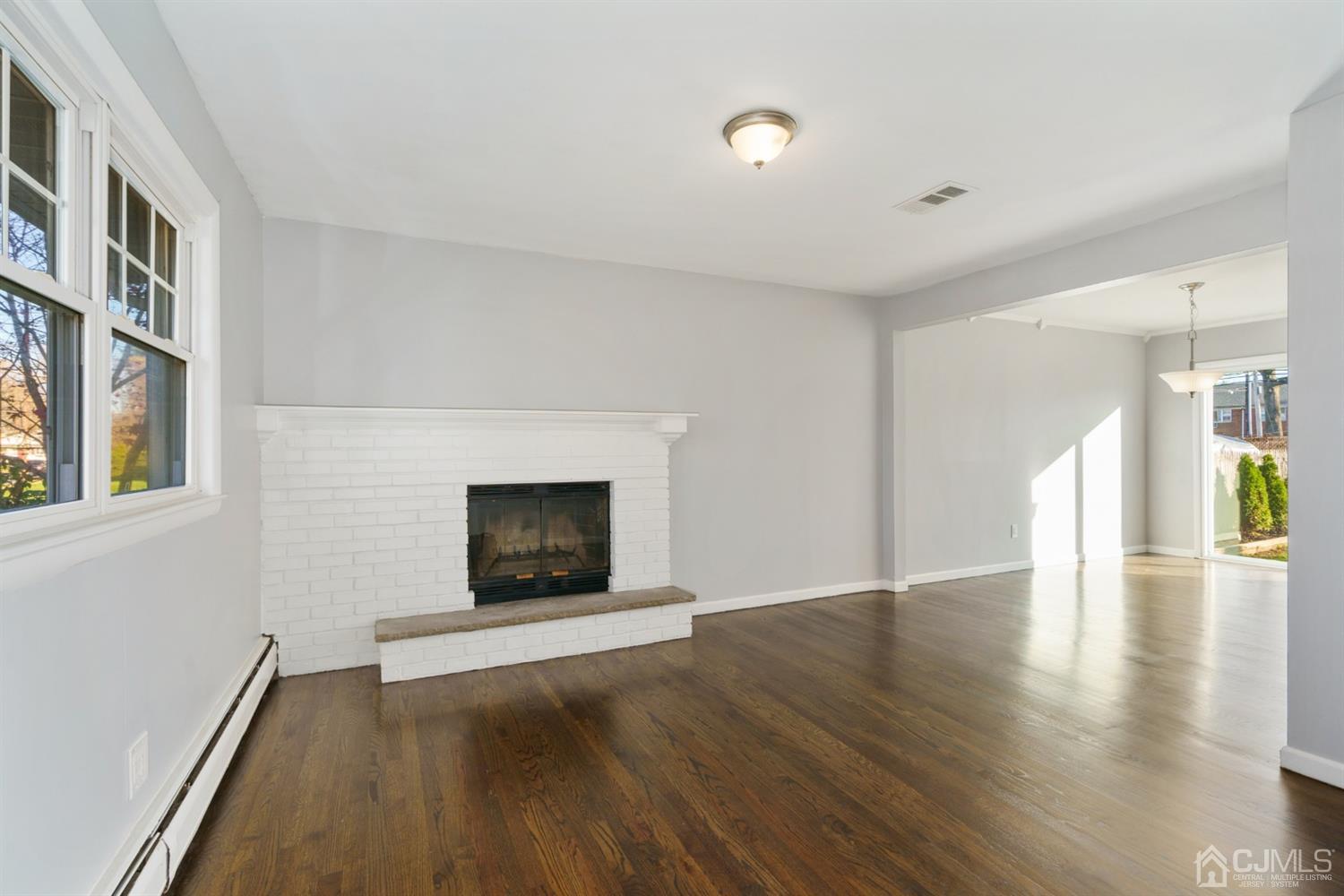403 Fulton Street Middlesex, NJ 08846 - Photo 4 of 31 a view of an empty room with wooden floor fireplace and a window