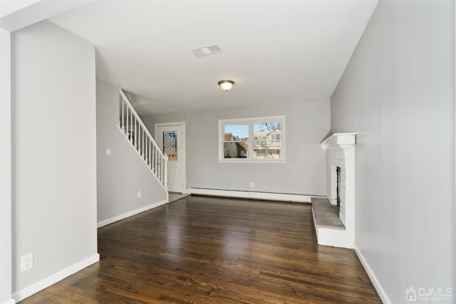 403 Fulton Street Middlesex, NJ 08846 - Photo 5 of 31 a view of an empty room with wooden floor and a window